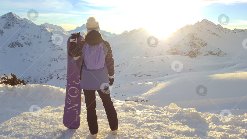 Скачать Девушка-сноубордистка на фоне гор. Закат на Эльбрусе фотосток Ozero