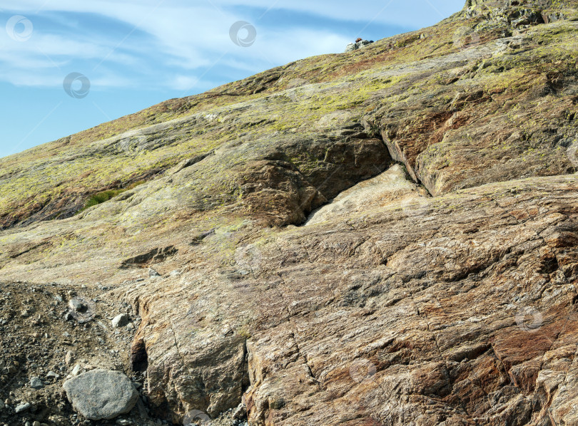 Скачать Неровный скалистый склон с трещинами и выбоинами. Крупный план. Фон из натурального камня. фотосток Ozero