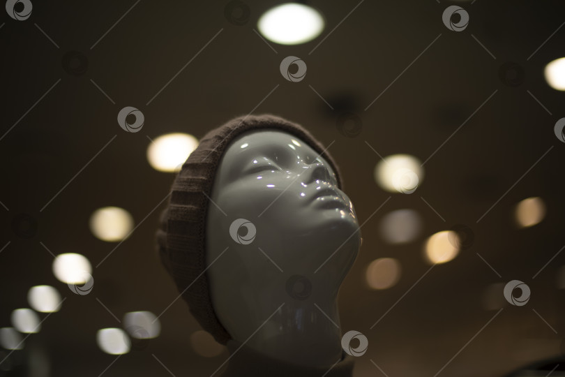 Скачать Манекен в магазине одежды. Голова сделана из белого пластика. Подсветка на манекене. фотосток Ozero