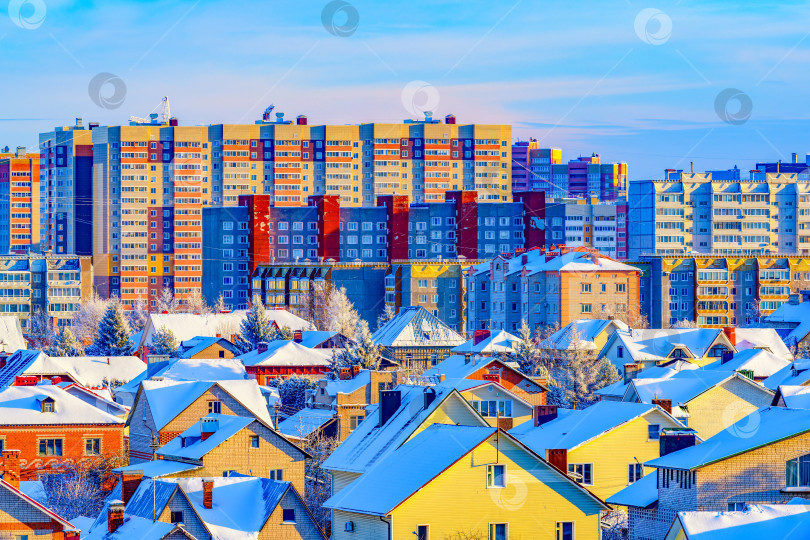 Скачать Городской пейзаж - вид на крыши жилых домов, коттеджей в городе Череповец. Холодным зимним днем вид на город с вершины горы на закате.Солнечные блики на снегу. фотосток Ozero