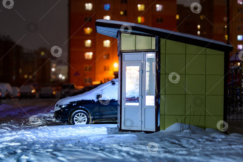 Скачать Ночной киоск или ночной рынок в городе во дворе многоэтажных жилых домов. Ночная торговля зимой. фотосток Ozero