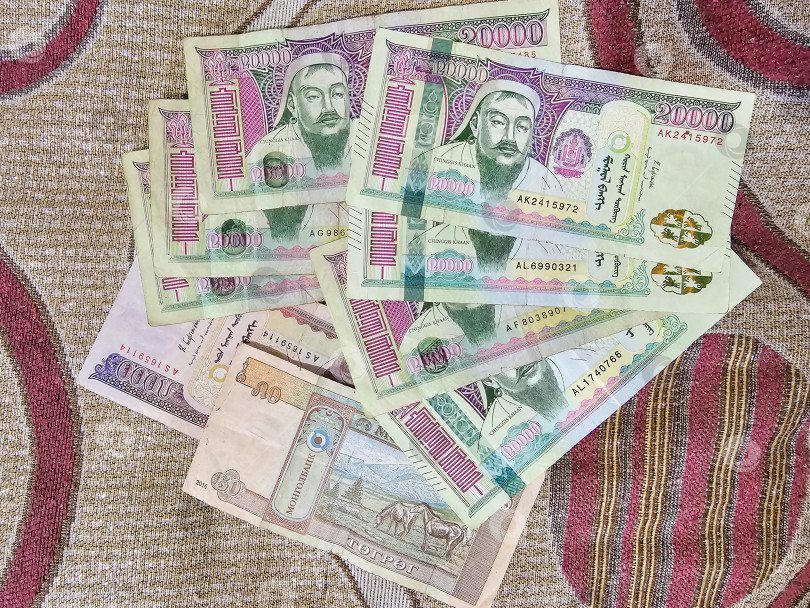 Скачать Монгольские бумажные деньги разложены веером на ковре. фотосток Ozero