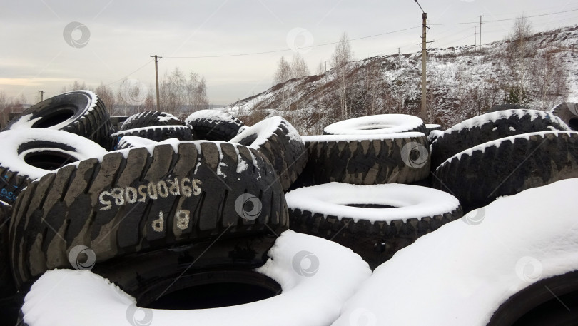 Скачать Резиновые шины карьерной спецтехники на открытом складе зимой фотосток Ozero