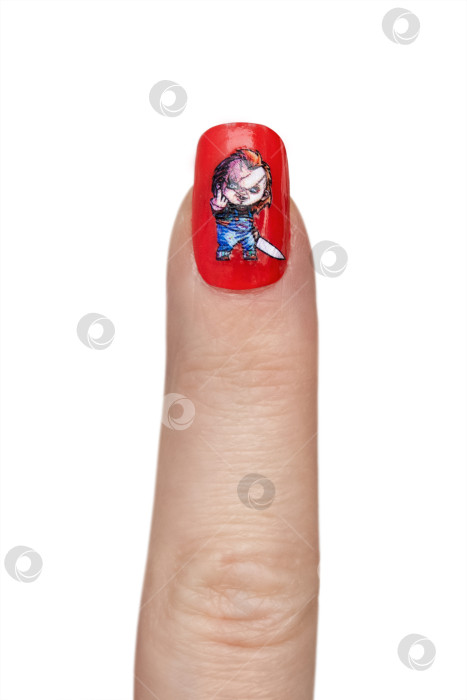 Скачать Указательный палец с красным лаком и изображением куклы Чаки, изолировано на белом фоне фотосток Ozero