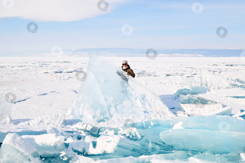 Скачать Молодая женщина стоит за огромной глыбой льда. фотосток Ozero