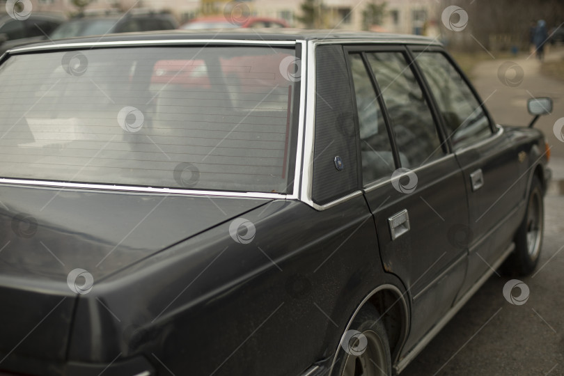 Скачать Старая машина на стоянке. Машина черного цвета. Автомобиль снят сзади. фотосток Ozero