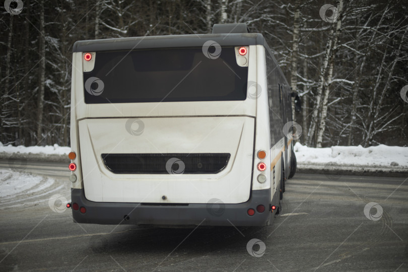 Скачать Автобус зимой поворачивает на дороге. Транспорт на шоссе. Общественный транспорт разворачивается. фотосток Ozero