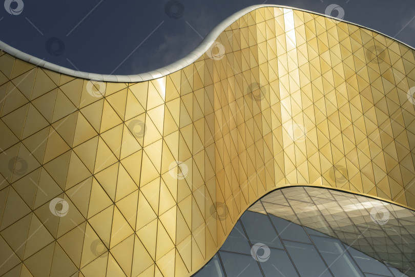 Скачать Современное здание из стекла и металла. Золотой цвет в архитектуре здания. Современный стиль здания. фотосток Ozero