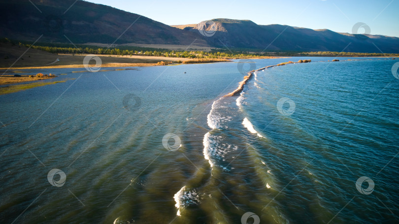 Скачать Озеро Байкал с воздуха. Песчаная коса. Волны у берега в лучах заходящего солнца. фотосток Ozero