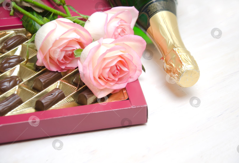 Скачать конфеты, розы и шампанское на белом деревянном фоне фотосток Ozero