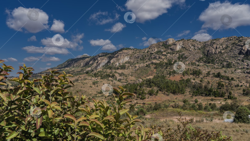 Скачать Гора со скалистыми склонами на фоне голубого неба и облаков. фотосток Ozero