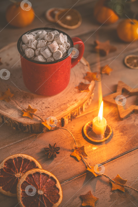 Скачать Милая уютная зимняя композиция. красная кружка, зефир, апельсины и рождественские гирлянды. фотосток Ozero