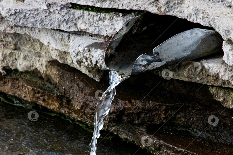 Скачать Струйка воды в роднике на камнях фотосток Ozero