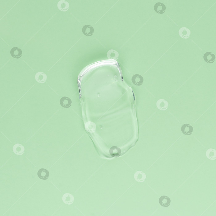 Скачать Мазок прозрачного крема для лица и тела на зеленом фоне фотосток Ozero