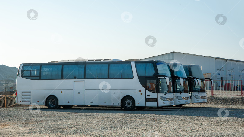 Скачать Пассажирские вахтовые автобусы стоят в ряд на строительной площадке фотосток Ozero