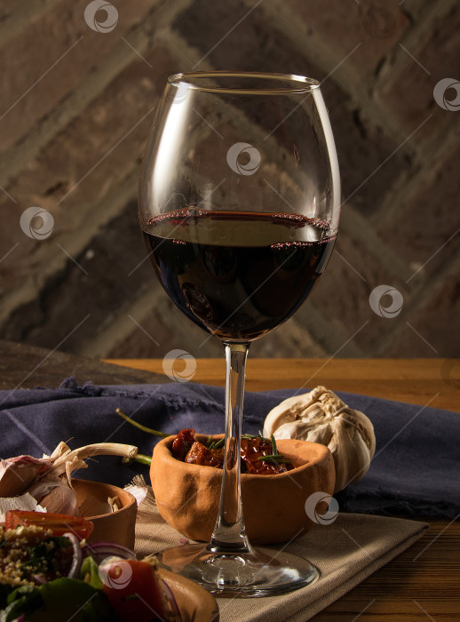Скачать Бокал вина на столе с блюдами фотосток Ozero