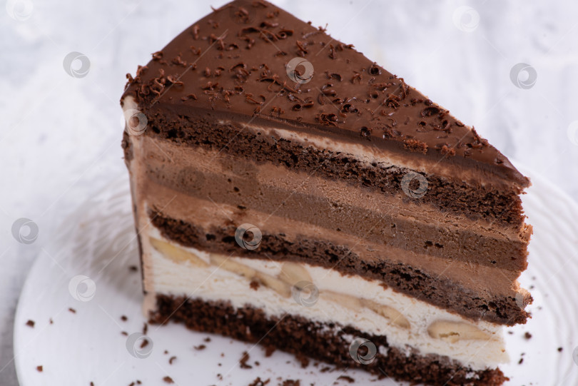 Скачать Крупный план шоколадного торта, нарезанного ломтиками, на белой тарелке. фотосток Ozero