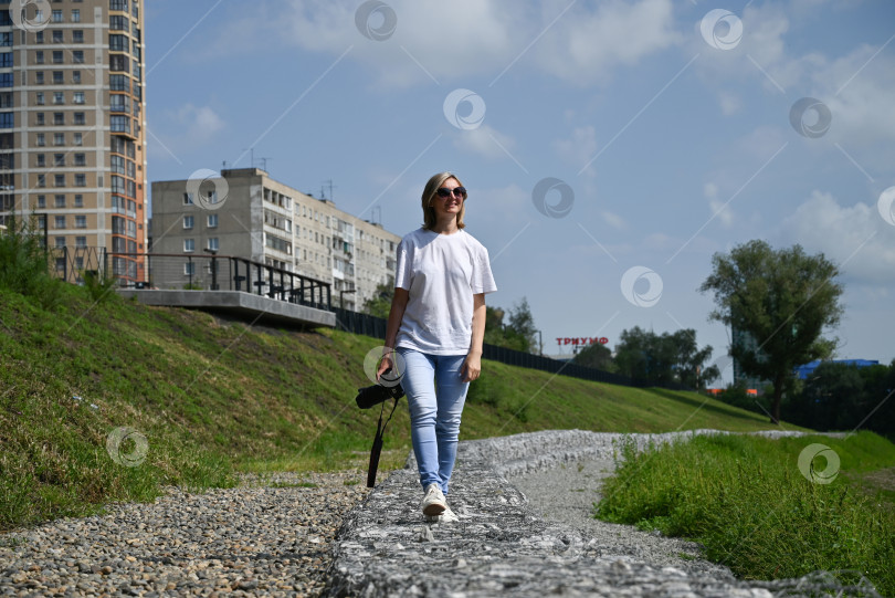 Скачать женщина-фотограф с фотоаппаратом в руках прогуливается по улицам города фотосток Ozero