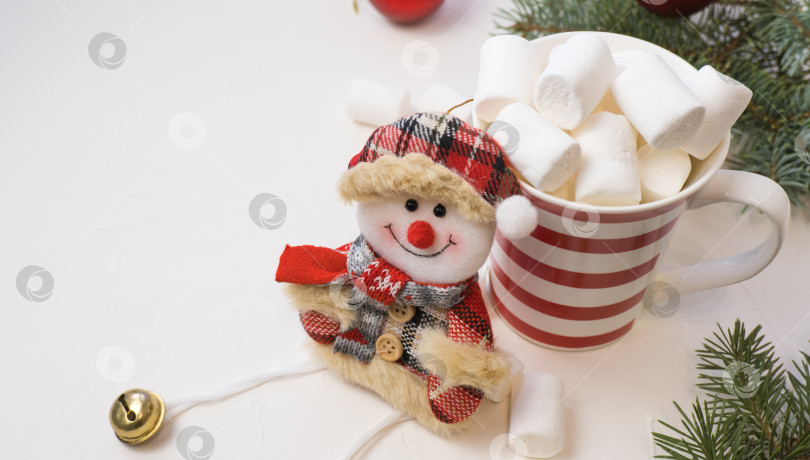 Скачать Традиционный горячий шоколад с зефиром и снеговиком на белом текстурированном фоне. Тема рождественского напитка. фотосток Ozero