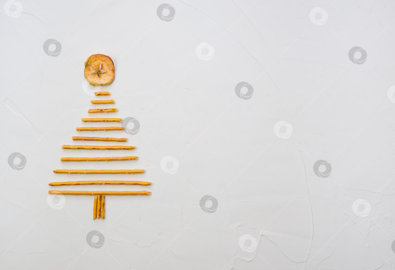 Скачать Рождественская елка, сделанная из печенья pepero straws, на белом текстурном фоне. Вид сверху с пробелом для текста справа фотосток Ozero
