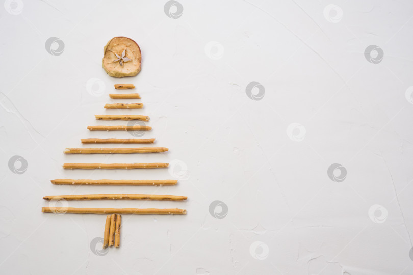 Скачать Рождественская елка, сделанная из печенья pepero straws, на белом текстурном фоне. Вид сверху с пробелом для текста справа фотосток Ozero