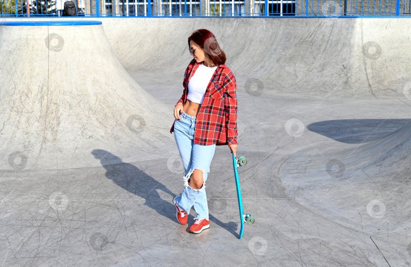 Скачать Активная женщина средних лет катается на скейтборде по пустой дороге или шоссе. Обычная городская женщина, отдыхающая на скейтборде после работы. Концепция современного образа жизни фотосток Ozero