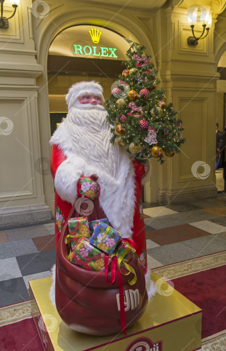 Скачать Новогодние украшения  в ГУМе. Фигура Деда Мороза с елкой и мешком новогодних подарков. фотосток Ozero