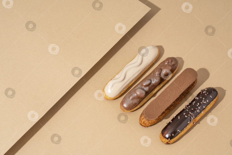 Скачать Набор восхитительных пончиков с глазурью самых разных вкусов, разложенных на картонной бумаге в привлекательной витрине фотосток Ozero
