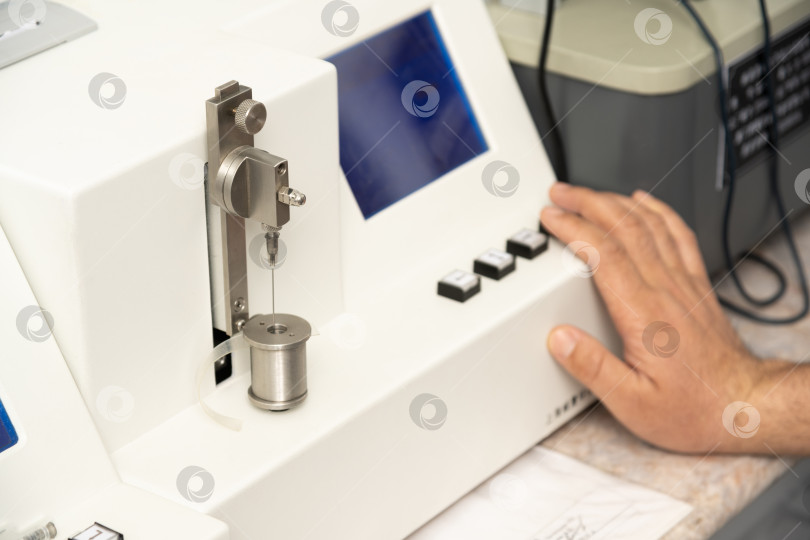 Скачать Снимок руки крупным планом, использующей медицинскую машину для тестирования и изготовления фармацевтических шприцев фотосток Ozero