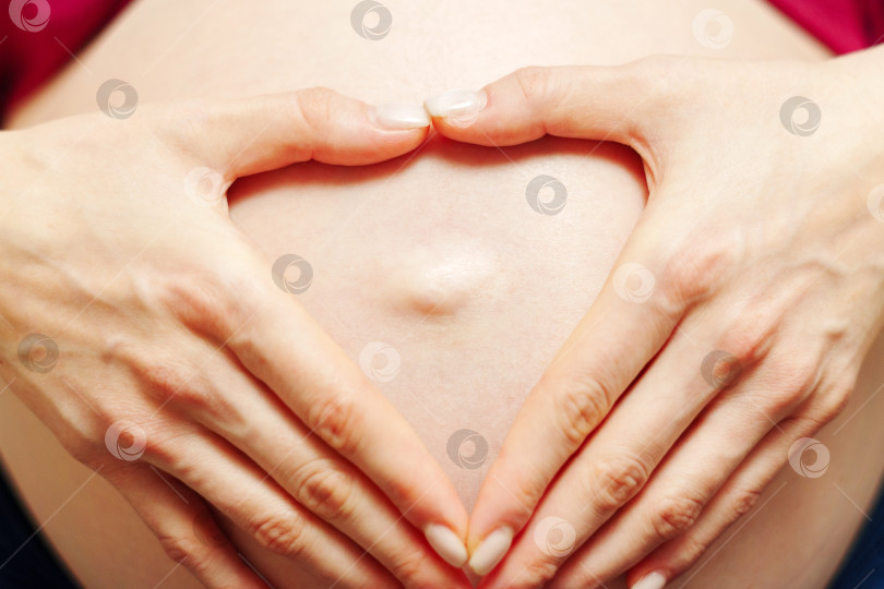 Скачать Беременная женщина держит руки на животе. Третий триместр. Беременность. Ожидание чуда. Материнство фотосток Ozero