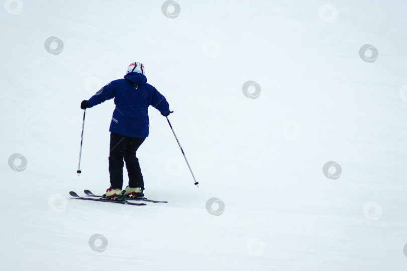 Скачать Человек спускается на лыжах со склона, зимние развлечения, зимнее время. Скопировать пробел фотосток Ozero