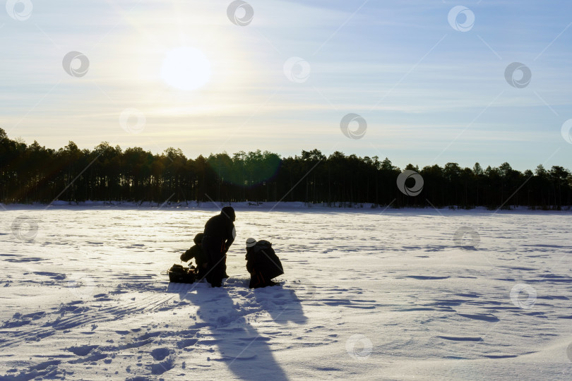Скачать Люди наслаждаются зимней рыбалкой. Зимние развлечения фотосток Ozero