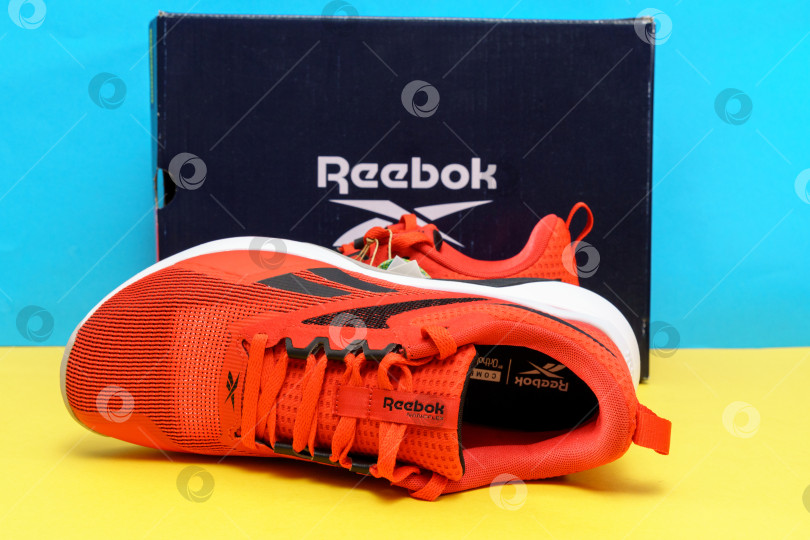 Скачать Тюмень, Россия-03 августа 2023 года: Мужские кроссовки Reebok модели Nanoflex TR V2. Желтый и синий фон фотосток Ozero