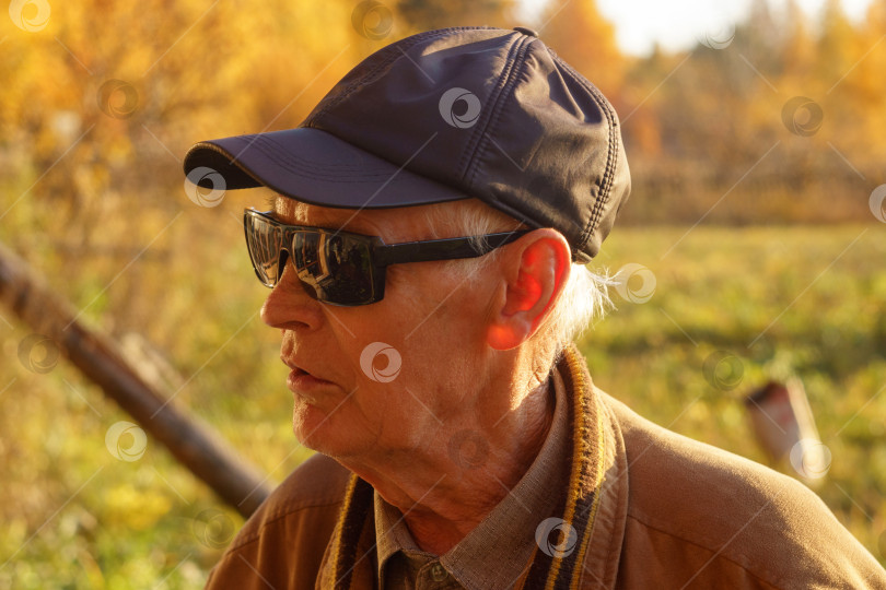 Скачать Один современный пожилой кавказец в солнцезащитных очках изображает счастливого дедушку мужского пола с бородой и в шляпе-кепке. фотосток Ozero
