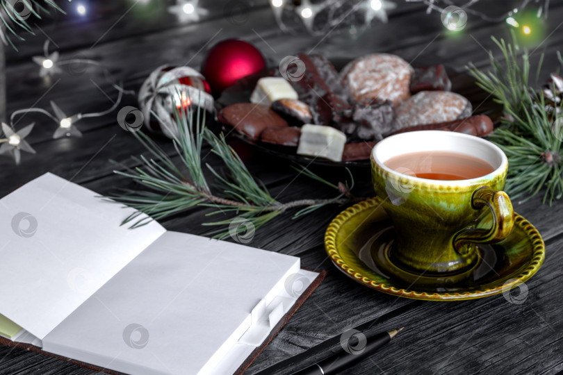 Скачать Чистый блокнот для заметок на Рождество и Новый год. Чай со сладостями на столе, украшенном ветками рождественской елки с шишками и украшениями. Планы и итоги фотосток Ozero