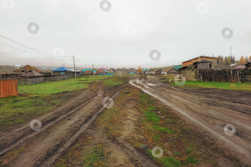 Скачать Сельская дорога, размытая дождями. Осенняя грунтовая дорога, непролазная грязь через деревню. Алтайский край. фотосток Ozero