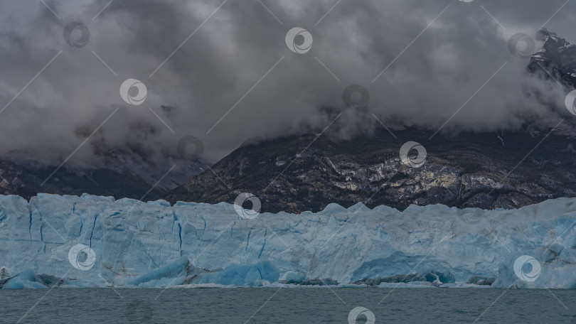 Скачать Стена голубого льда с трещинами возвышается в бирюзовом озере. фотосток Ozero
