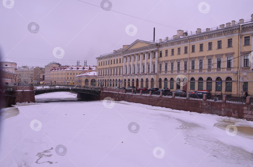 Скачать Санкт-Петербург, Россия – 24.12.2023: Вида на набережную реки Мойка, дом Адамини и Мало-Конюшенный мост в зимний день в Санкт-Петерубрге фотосток Ozero