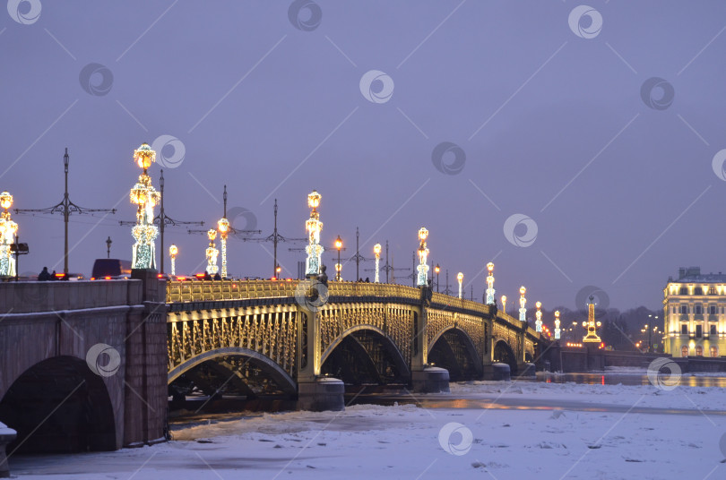 Скачать Санкт-Петербург, Россия – 24.12.2023: Троицкий мост в Санкт-Петербурге, украшенный к Новому году фотосток Ozero