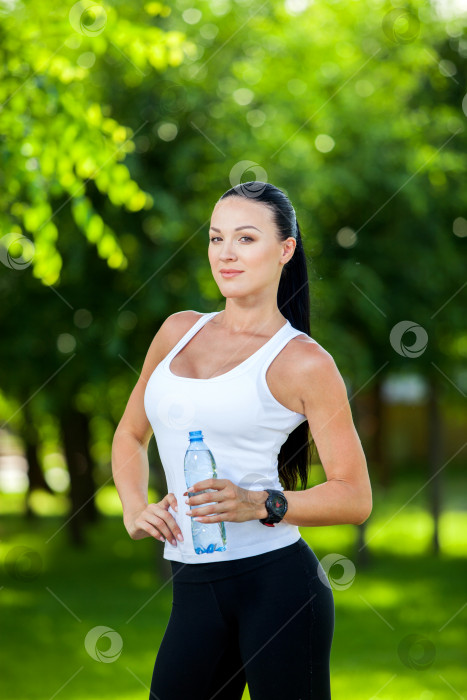 Скачать женщина-спортсменка делает перерыв, она пьет воду, выходит на пробежку в жаркий день фотосток Ozero