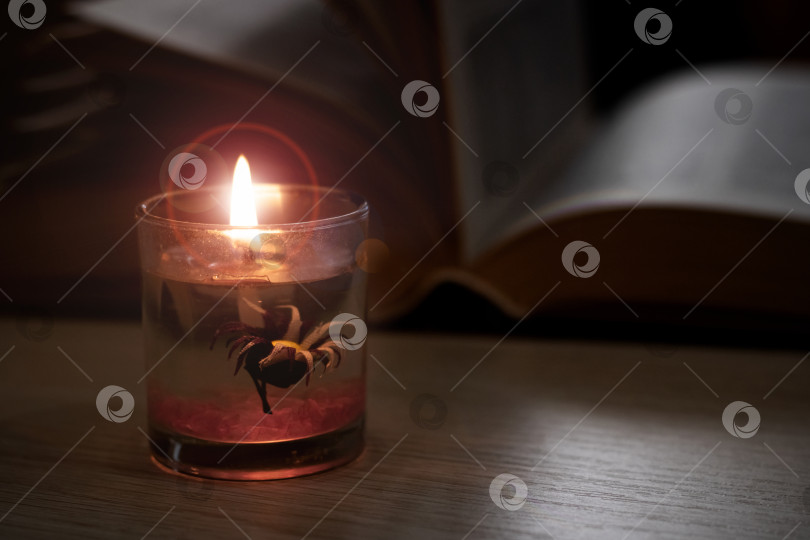 Скачать Яркая свеча в темноте на фоне книги фотосток Ozero