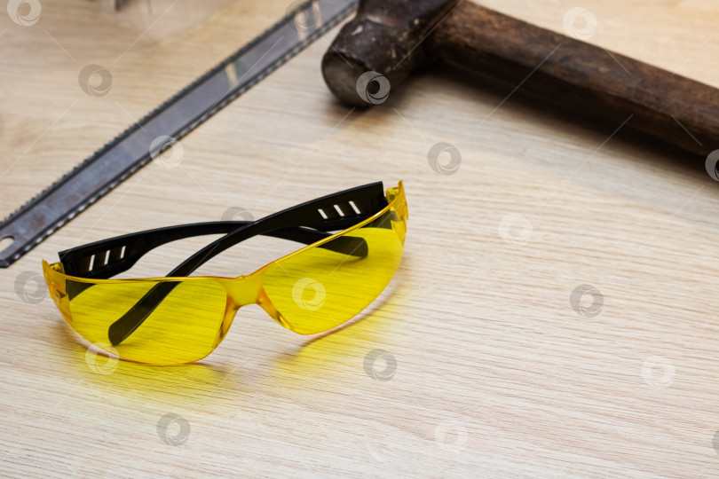 Скачать Желтые защитные очки и инструменты на деревянном столе фотосток Ozero
