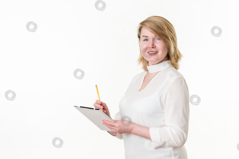 Скачать Портрет бизнесвумен, смотрящей в камеру, пишущей карандашом в блокноте. Концептуальный белый воротничок фотосток Ozero