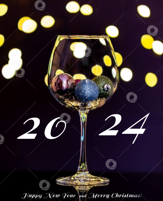 Скачать Фотография романтического праздничного интерьера с игрушечными рождественскими шарами в бокале для вина в селективном фокусе с отражениями. Открытка с Рождеством и Новым 2024 годом.Поздравительная открытка. фотосток Ozero