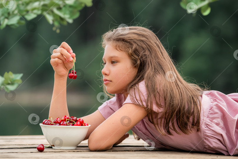 Скачать девочка ест вишни на природе фотосток Ozero