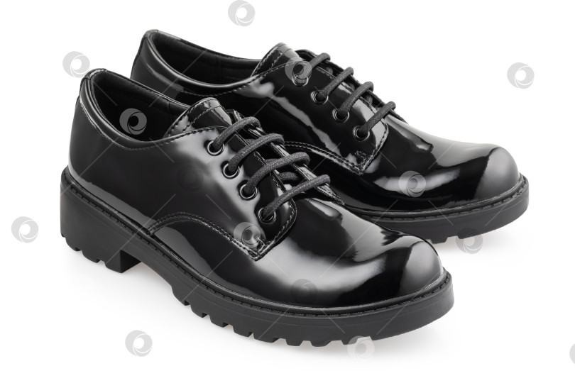 Скачать Пара черных лакированных ботинок на шнурках, выделяющихся на белом фоне фотосток Ozero