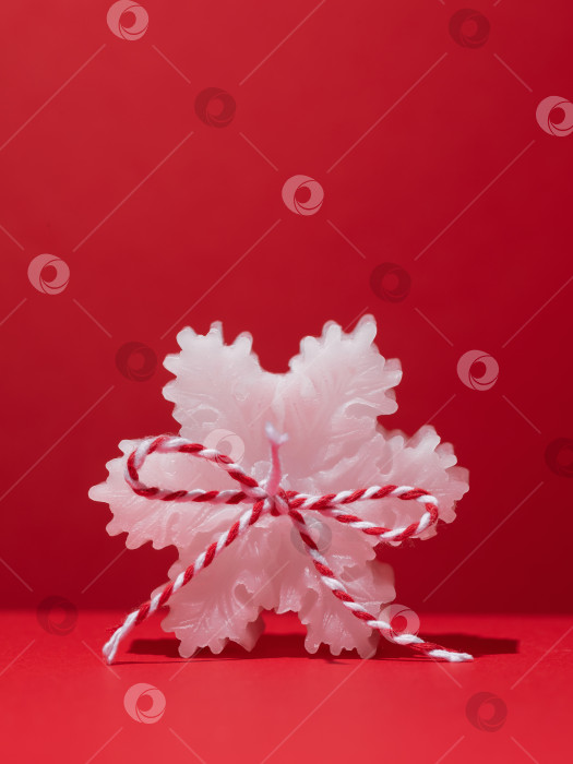 Скачать Одна белая ароматическая свеча в форме снежинки на красном фоне с пробелом для копирования фотосток Ozero
