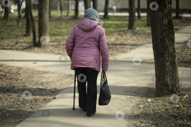 Скачать Пенсионерка в городе. Женщина с тростью на улице. Мужчина идет по дороге. фотосток Ozero