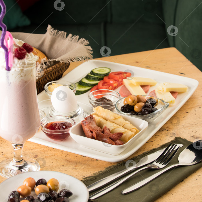 Скачать Снимок крупным планом белой тарелки для завтрака и чашки со смузи на деревянном столе фотосток Ozero