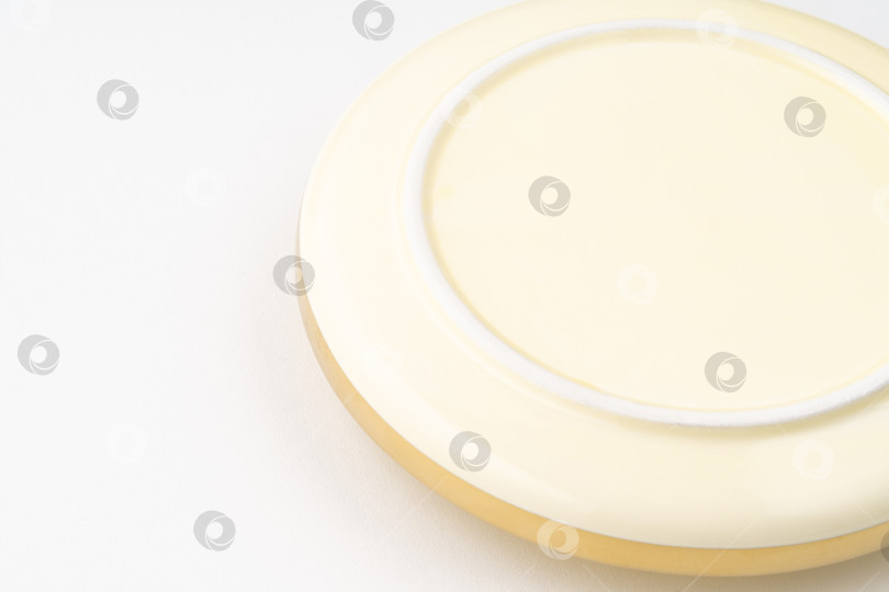 Скачать Снимок крупным планом нижней стороны золотой тарелки на белом фоне фотосток Ozero